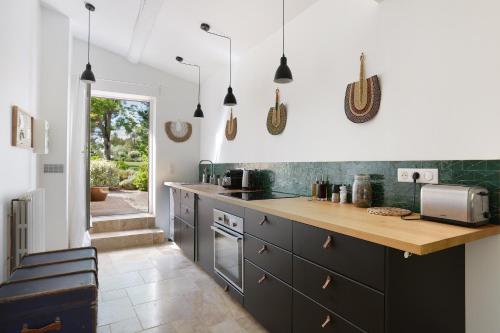 a kitchen with black cabinets and a counter at Domaine Les Petites Vaines in Goult