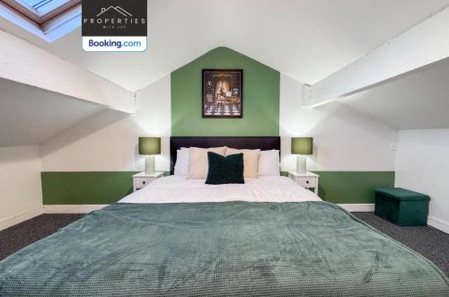 a bedroom with a large bed with green walls at Modern 3BDR House By Properties With Joy Short Lets Manchester Perfect For Contractors & Large Groups With Free WiFi & Parking in Ashton under Lyne