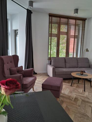 a living room with a couch and a table at CanvasHome Apartamenty Aparthotel 250m od Rynku in Katowice