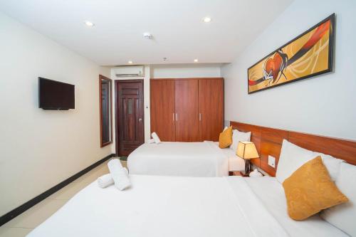 a hotel room with two beds and a tv at Quoc Cuong Hotel & Apartment Danang by Haviland in Da Nang