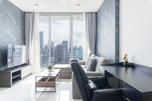 a living room with a couch and a tv at Hyde Sukhumvit 11 Bangkok in Bangkok