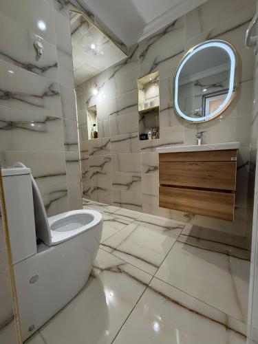 a bathroom with a white toilet and a mirror at TOP Nour D'asilah in Asilah