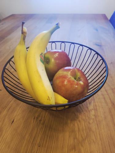 a bowl of fruit with apples and bananas on a table at Vila Hrastnica in Škofja Loka