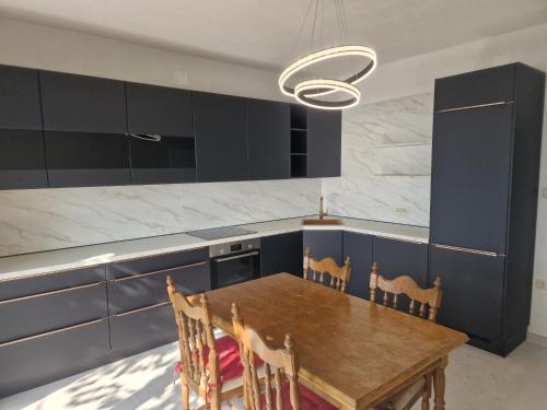 a kitchen with a wooden table and blue cabinets at Apartments by the sea Sveti Juraj, Senj - 2399 in Sveti Juraj