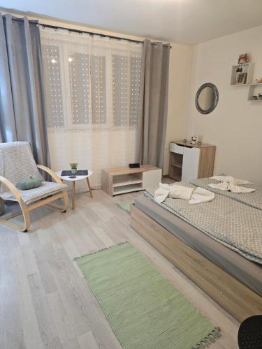 a bedroom with two beds and a chair and a window at Peshtera Cozy Apartment in Peshtera
