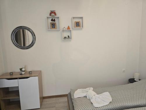 a bedroom with a bed and a mirror and a table at Peshtera Cozy Apartment in Peshtera