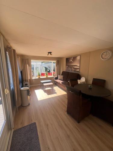 a living room with a couch and a table at Familiechalet Vechtdal in Diffelen