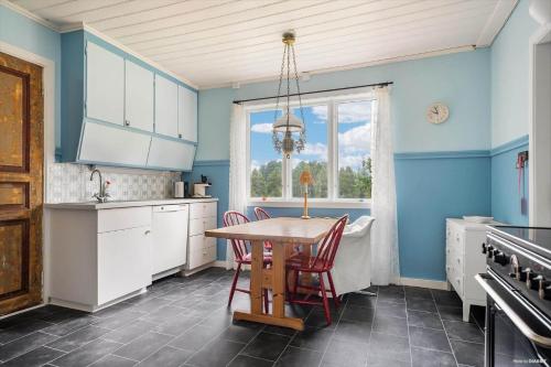 a kitchen with blue walls and a table and chairs at JON581-Vaernamo-Uppsala in Röshult