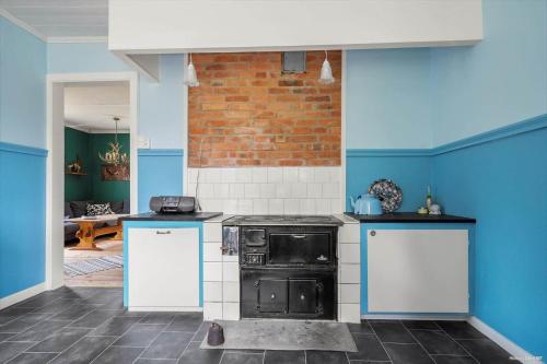 a kitchen with blue and white walls and an oven at JON581-Vaernamo-Uppsala in Röshult