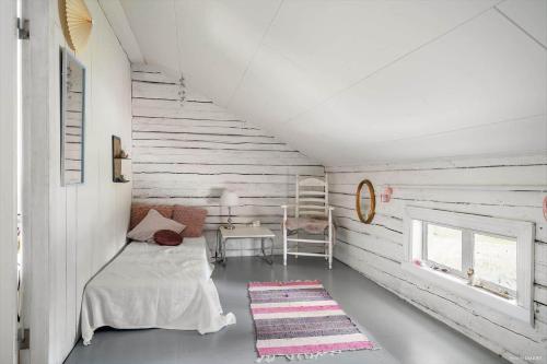 a white room with a bed and a desk at JON581-Vaernamo-Uppsala in Röshult