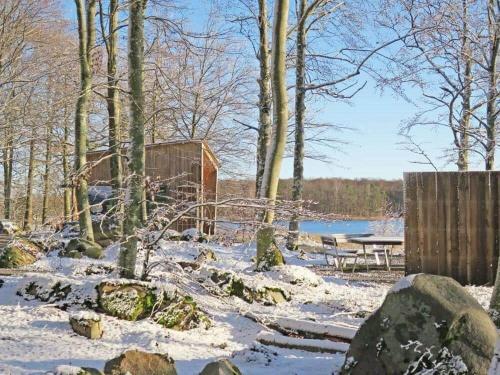 a snow covered yard with a picnic table and trees at KRO732-Urshult-Berg-Faekten in Urshult