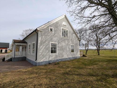 a gray house with a porch and a yard at OGO780-Mjoelby-Norrby-Naesloesegard-1 in Mjölby