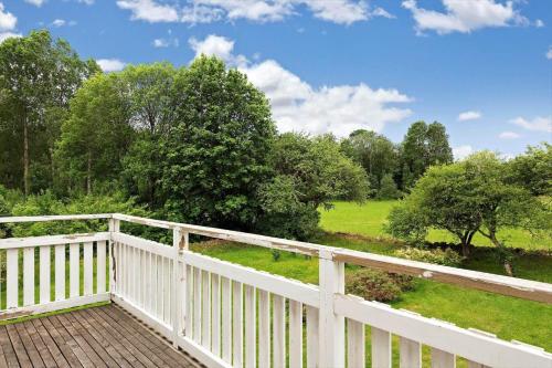 a wooden deck with a white fence and trees at KRO084-Linneryd-Skogsholm-Skogsryd in Sandvik