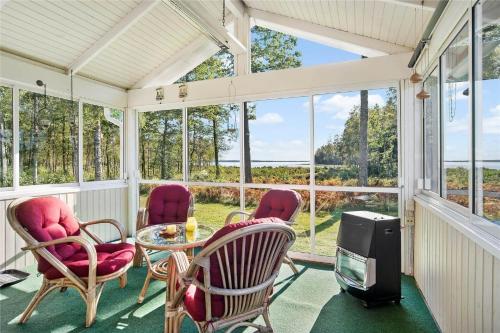 a screened porch with chairs and a table and a tv at KRO273-Bolmsoe-Tjust-Lund in Bolmstad