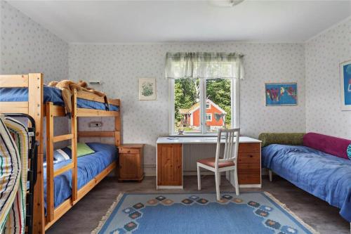 a bedroom with bunk beds and a desk and a window at KRO047-Urshult-Vaesterbotorp-Bosgard in Urshult