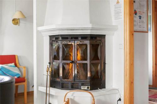 a fireplace with glass doors in a living room at KRO043-Urshult-Vaesterbotorp-Bosgard in Urshult