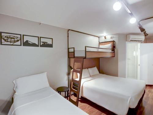 two beds in a room with two bunk beds at ibis Copacabana Posto 2 in Rio de Janeiro