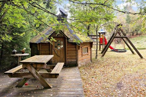 a wooden cabin with a picnic table and a playground at VGO787-Hacksvik-Hacksvik-1 in Sjötofta