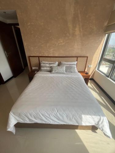 a bedroom with a large bed with white sheets and pillows at Colombo, Trizen Luxury Apartments, Sri Lanka in Colombo