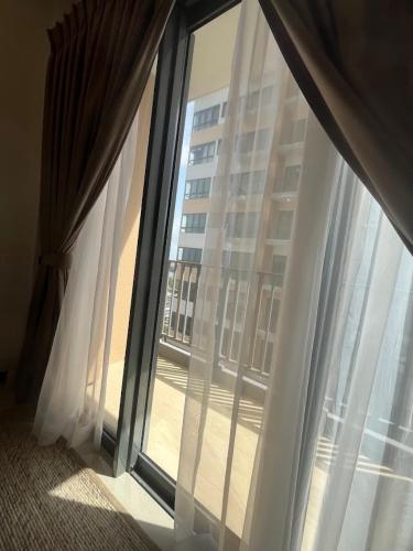 a window with white curtains and a view of a building at Colombo, Trizen Luxury Apartments, Sri Lanka in Colombo