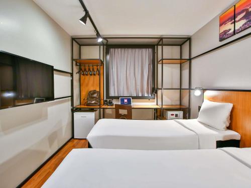 a hotel room with two beds and a desk at ibis Copacabana Posto 2 in Rio de Janeiro