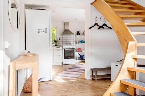 a kitchen with white walls and wooden floors and a staircase at KRO191-Aelmhult-Boastad-Lillstugan in Länshult