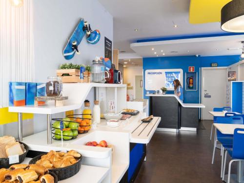 a bakery with blue walls and a counter with bread at Ibis Budget Madrid Centro Las Ventas in Madrid