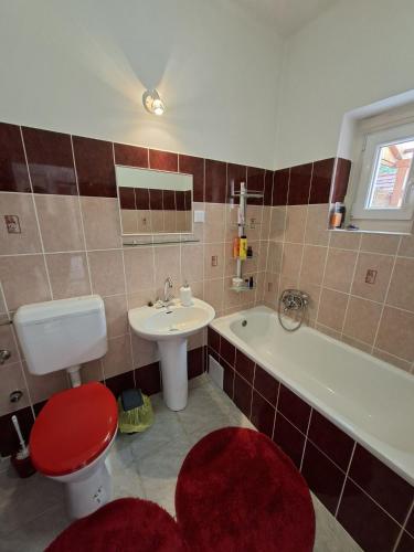 a bathroom with a toilet and a sink and a tub at Apartalatt Vendégház in Eger