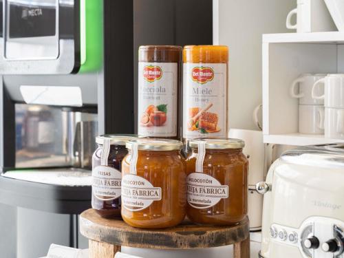 three jars of honey on a table in a kitchen at Ibis Budget Madrid Centro Las Ventas in Madrid