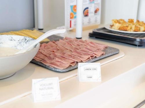 a pile of ham on a counter in a store at Ibis Budget Madrid Centro Las Ventas in Madrid