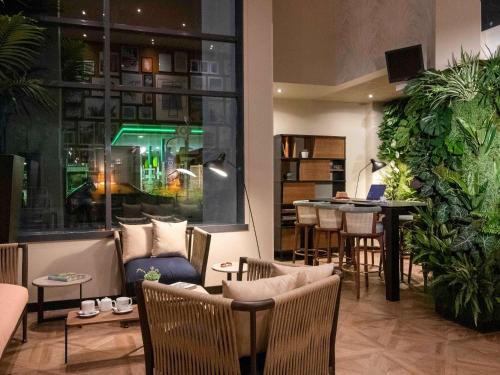 a restaurant with a bar with chairs and a table at Novotel Suites Nice Airport in Nice