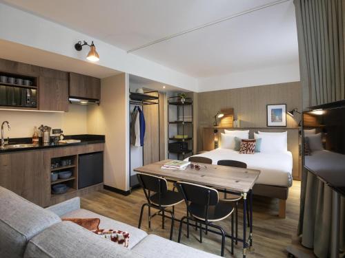 a hotel room with a bed and a table at Novotel Suites Nice Airport in Nice
