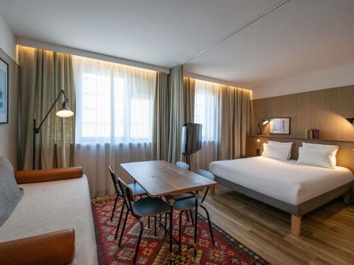 a hotel room with a bed and a table at Novotel Suites Nice Airport in Nice