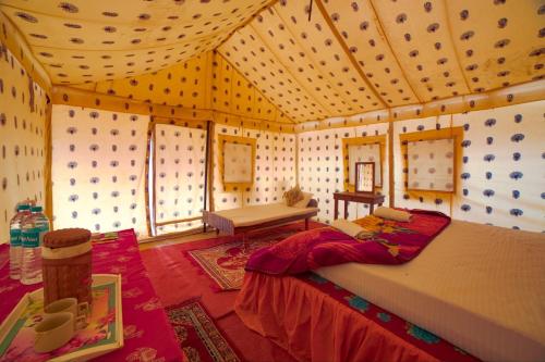 a bedroom with a large bed in a room at Royal Gadhvi Desert Camp in Sām