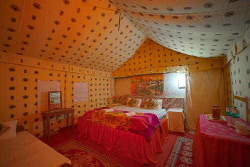 a bedroom with a bed in a room at Royal Gadhvi Desert Camp in Sām