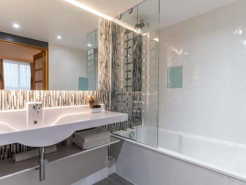 a bathroom with a sink and a shower at Novotel Edinburgh Park in Edinburgh