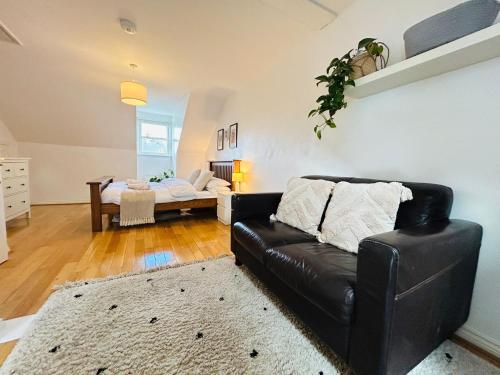 a living room with a black leather couch and a table at Durham City Centre 5 bedroom House in Gilesgate