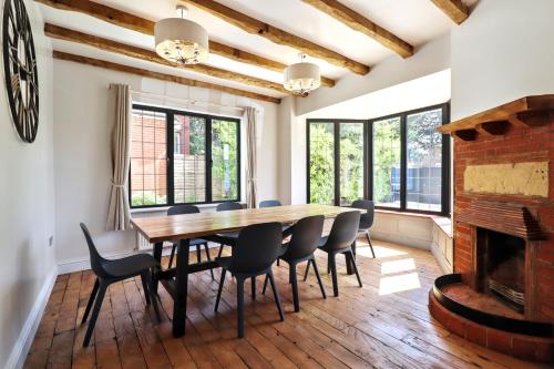 a dining room with a table and chairs and a fireplace at Beautiful arts and crafts home in East Grinstead
