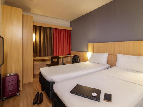 a hotel room with two beds and a laptop on the bed at ibis Petrolina in Petrolina