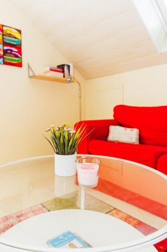 a living room with a red couch and a glass table at Studio comfort in Bischenrech