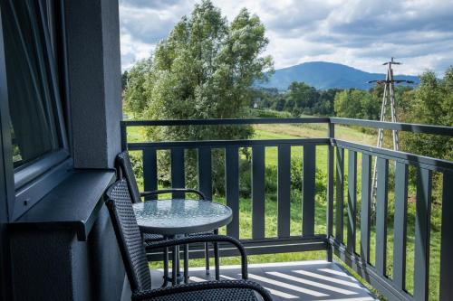 a table and chairs on a balcony with a view at Zajazd Tadeo in Pietrzykowice