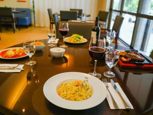 a table with a plate of food and glasses of wine at Novotel RJ Santos Dumont in Rio de Janeiro