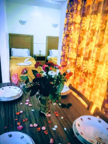 a table with a vase of flowers on top of it at Apparts-hôtel ISNI in Agadir