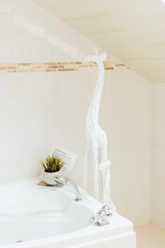 a bathroom with a white sink with a plant at Studio comfort in Bischenrech