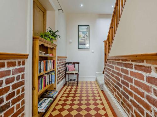 a room with a brick wall and a book shelf at 4 Bed in Bude SSHAM in Stratton