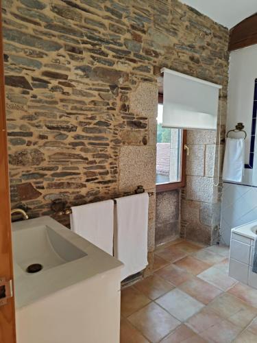a kitchen with a stone wall and a sink at Casa da Queira in Ares