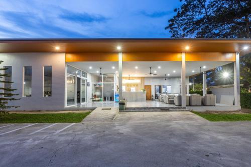 a large white house with a garage at night at Andaman Sea Best Pool Access and Villas in Phuket Town