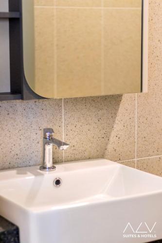 a white sink in a bathroom with a mirror at 22 Macalisterz by ALV in George Town