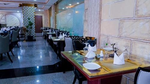 a restaurant with a row of tables and chairs at AA Hotels, Suites and Apartments in Abuja