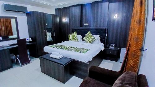 a bedroom with a large bed and a mirror at AA Hotels, Suites and Apartments in Abuja